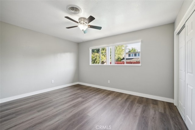 unfurnished bedroom with ceiling fan, a closet, and dark hardwood / wood-style flooring