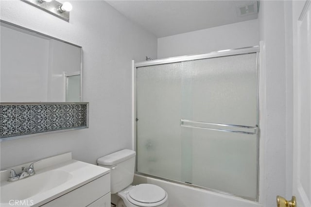 full bathroom featuring vanity, combined bath / shower with glass door, and toilet