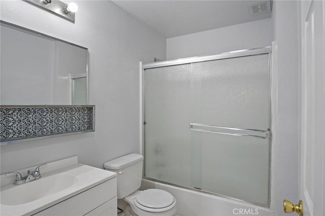 full bathroom featuring vanity, shower / bath combination with glass door, and toilet