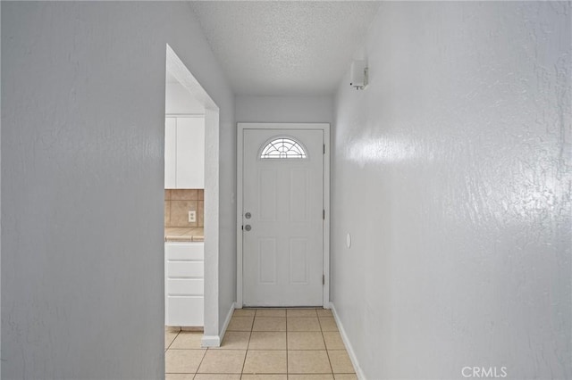 entryway featuring light tile patterned floors and a textured ceiling