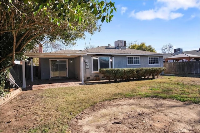 rear view of property with a lawn and a patio