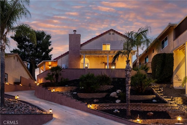 view of front of home featuring stucco siding and a chimney