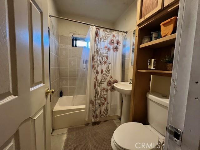 full bathroom with toilet, shower / tub combo, tile patterned flooring, and sink