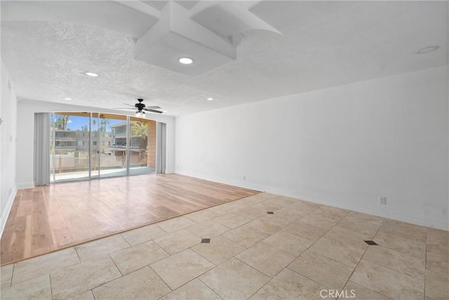 empty room featuring a textured ceiling, recessed lighting, a ceiling fan, light wood-style floors, and baseboards