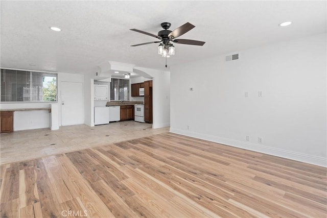 unfurnished living room featuring recessed lighting, a sink, a ceiling fan, baseboards, and light wood-type flooring