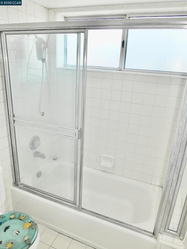 bathroom with bath / shower combo with glass door, tile patterned flooring, and plenty of natural light