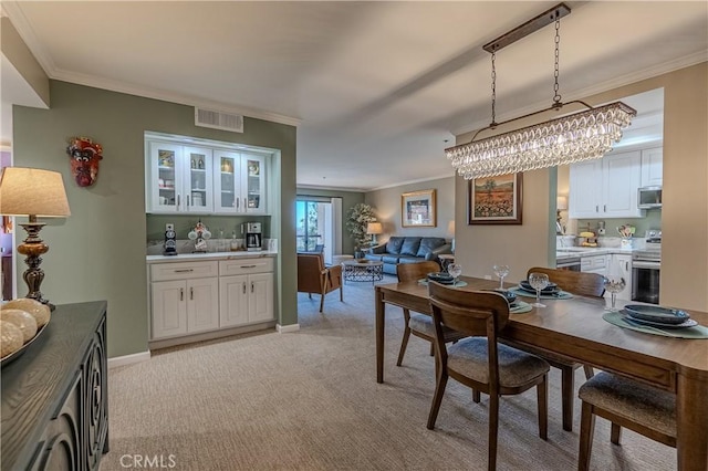 dining space featuring ornamental molding and light colored carpet