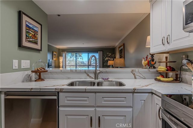 kitchen featuring white cabinets, appliances with stainless steel finishes, crown molding, light stone counters, and sink