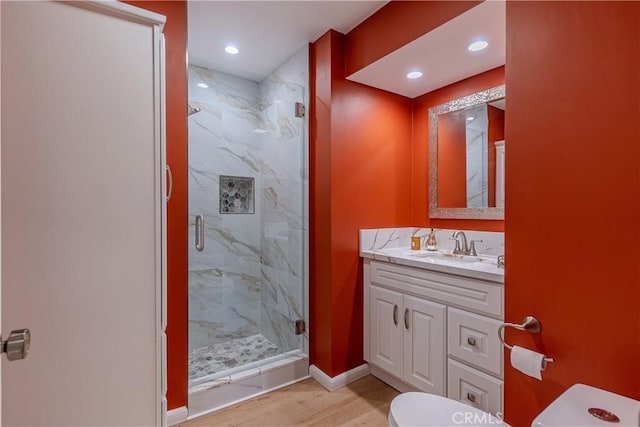 bathroom featuring toilet, wood-type flooring, walk in shower, and vanity