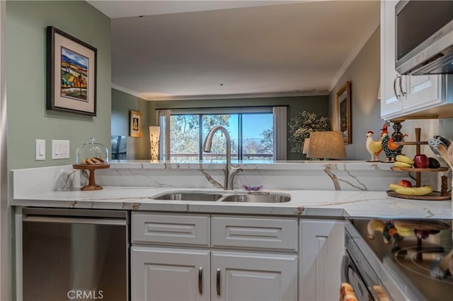 kitchen with sink, white cabinets, light stone countertops, and appliances with stainless steel finishes