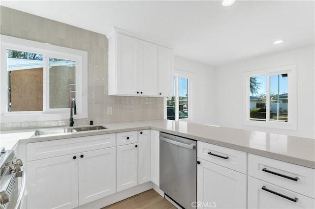 kitchen with sink, white cabinetry, dishwasher, and stove