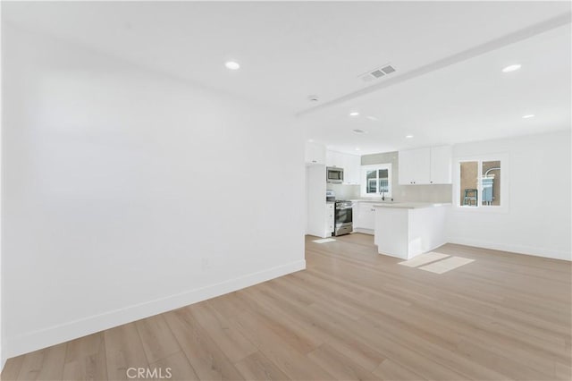 unfurnished living room featuring light hardwood / wood-style flooring and sink