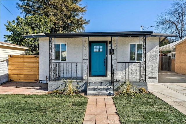 bungalow-style home with a front yard and covered porch