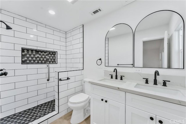 bathroom featuring toilet, vanity, and a shower with shower door