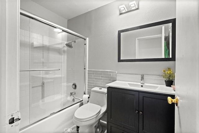 full bath featuring shower / bath combination with glass door, vanity, toilet, and tile walls