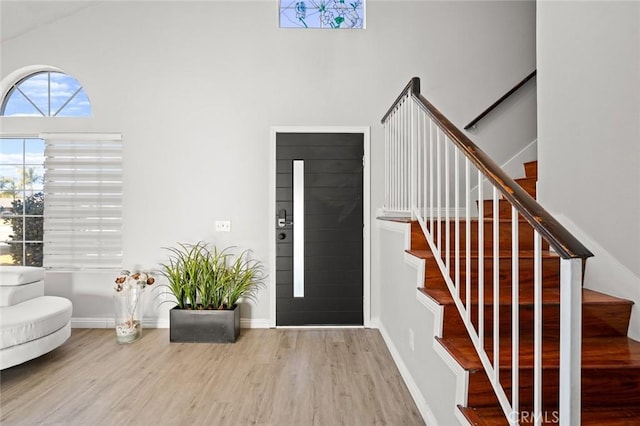 entryway featuring stairs, wood finished floors, and baseboards