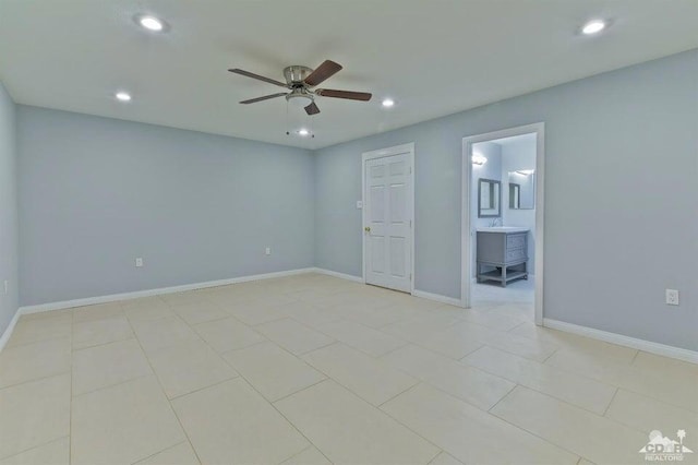 spare room with ceiling fan and light tile patterned floors