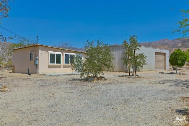 back of house with a mountain view and a garage