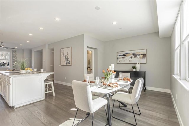 dining area with sink, light wood-type flooring, and ceiling fan