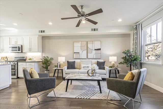 living room with dark wood-type flooring and ceiling fan