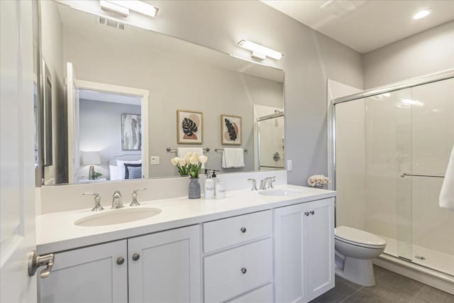 bathroom featuring toilet, an enclosed shower, vanity, and tile patterned floors