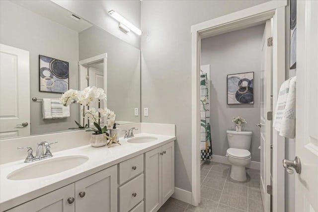 bathroom featuring toilet, vanity, and tile patterned floors