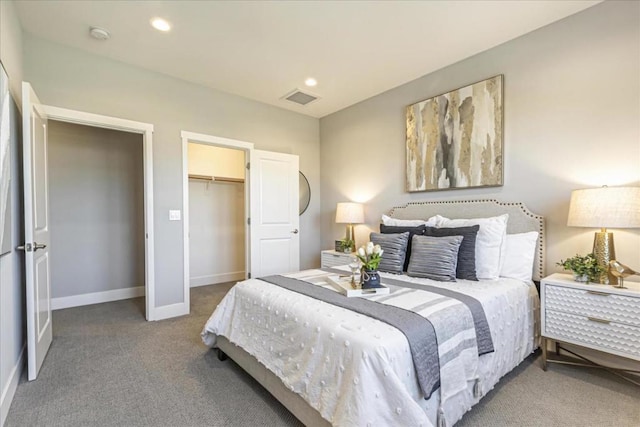 bedroom featuring a closet, a spacious closet, and carpet flooring