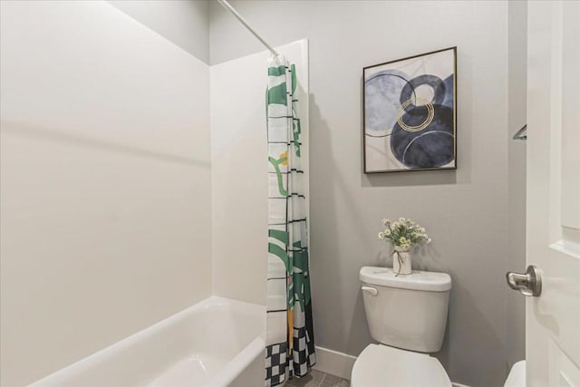 bathroom featuring shower / tub combo and toilet