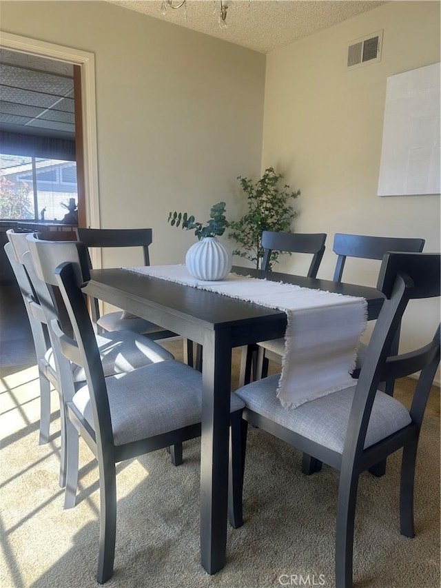 dining area with visible vents and a textured ceiling