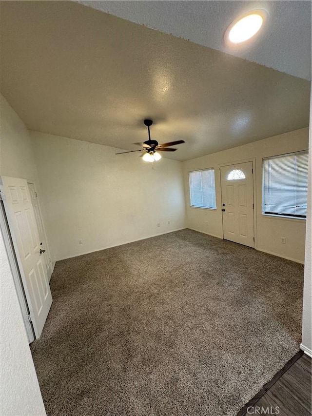 carpeted entryway featuring a textured ceiling and ceiling fan