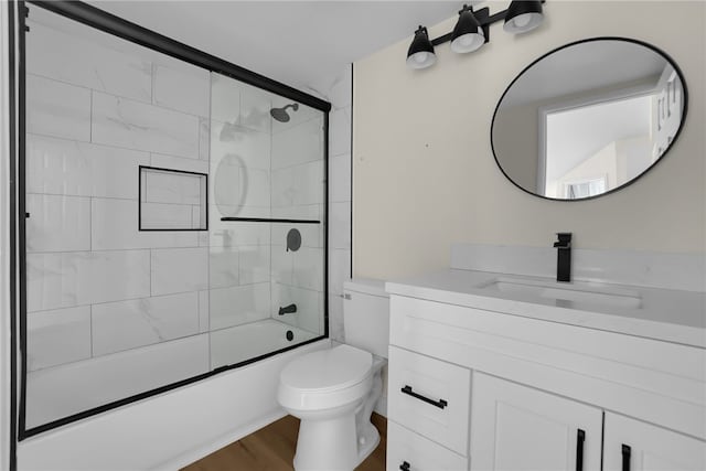 full bathroom with toilet, wood-type flooring, vanity, and enclosed tub / shower combo