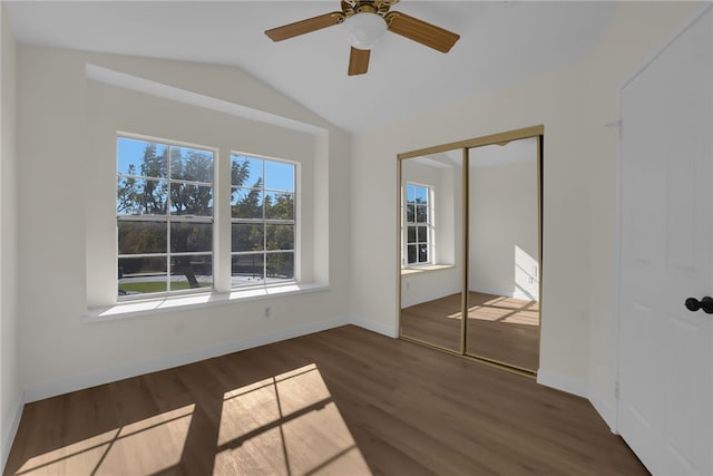 unfurnished bedroom featuring vaulted ceiling, ceiling fan, a closet, and dark hardwood / wood-style floors