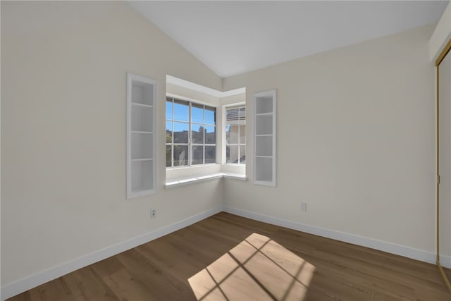 unfurnished room with lofted ceiling and dark wood-type flooring