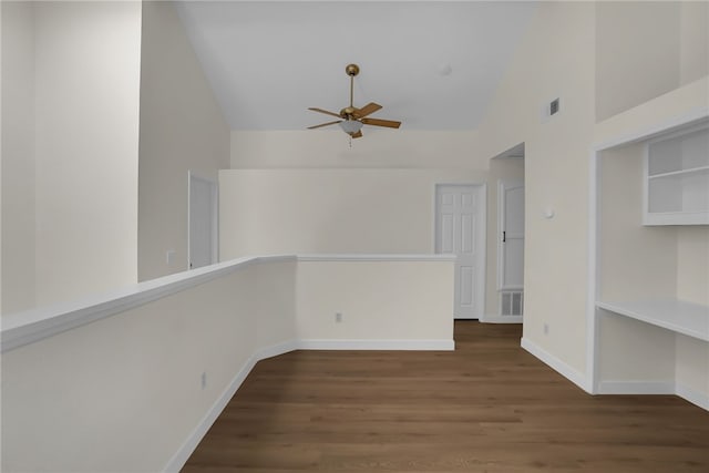 empty room with high vaulted ceiling, ceiling fan, built in features, and dark wood-type flooring