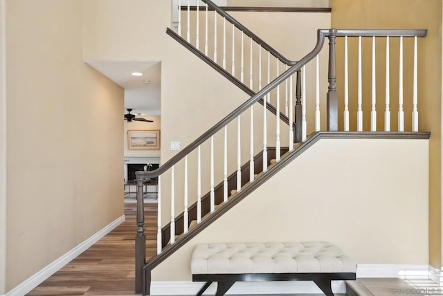 stairs with a brick fireplace and hardwood / wood-style flooring