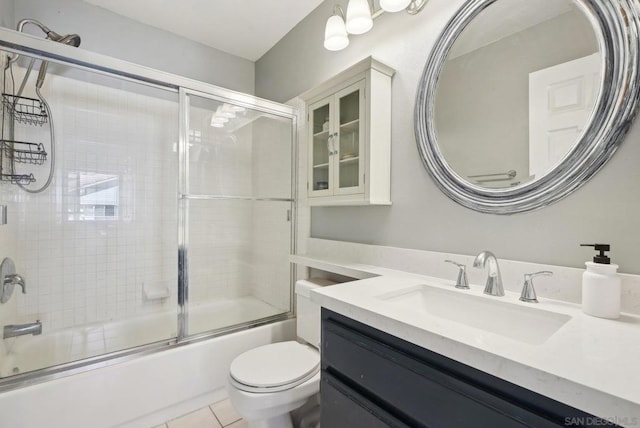 full bathroom with vanity, shower / bath combination with glass door, tile patterned floors, and toilet