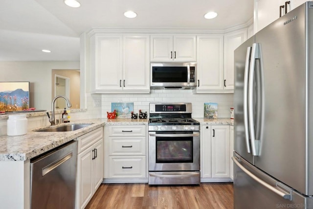 kitchen with appliances with stainless steel finishes, white cabinetry, and sink