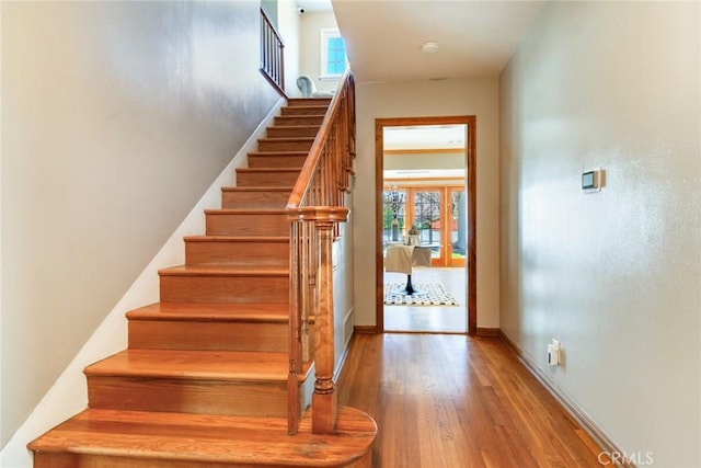 staircase featuring a wealth of natural light and hardwood / wood-style flooring