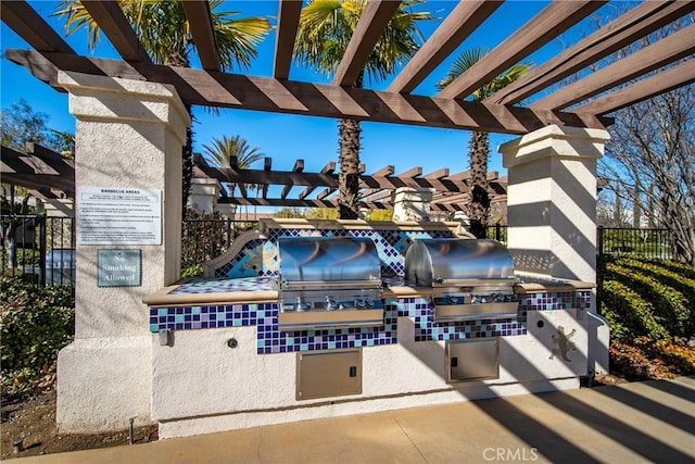 view of patio featuring a grill, a pergola, and exterior kitchen