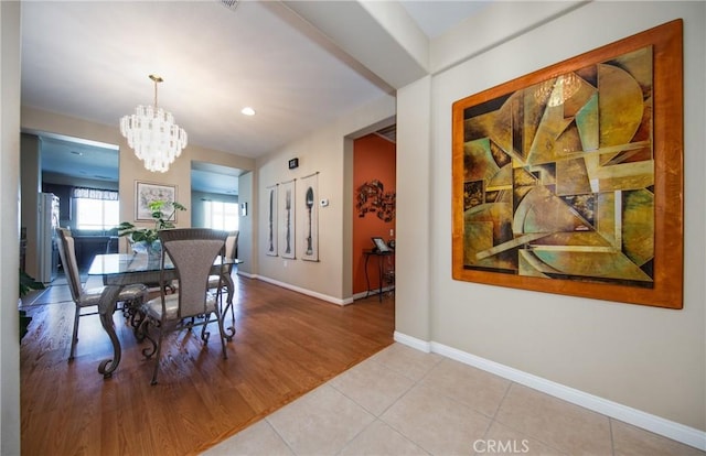 tiled dining space featuring an inviting chandelier