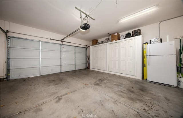 garage featuring a garage door opener and white fridge