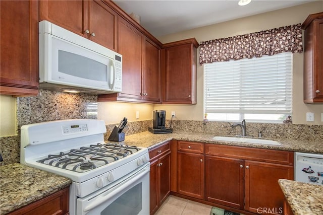 kitchen featuring sink, decorative backsplash, light tile patterned floors, light stone counters, and white appliances