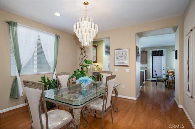 dining area featuring hardwood / wood-style floors and a notable chandelier