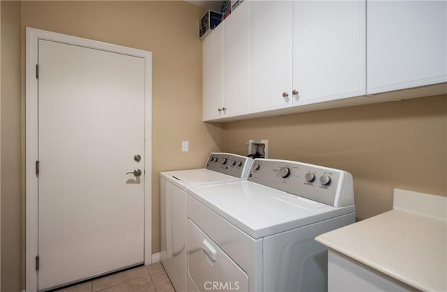 washroom with cabinets, separate washer and dryer, and light tile patterned floors