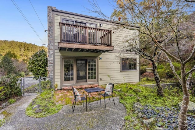 rear view of house featuring a patio area and a balcony