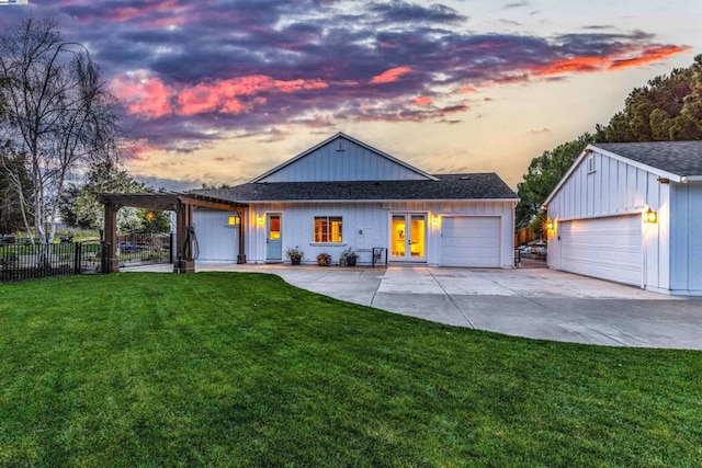 view of front facade with a garage, french doors, and a lawn