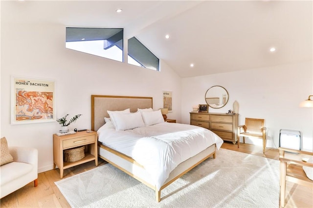 bedroom featuring hardwood / wood-style flooring and high vaulted ceiling