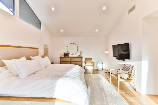 bedroom featuring light wood-type flooring and high vaulted ceiling