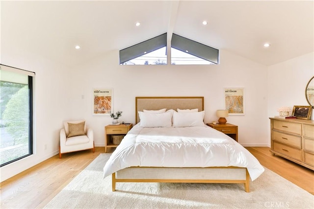 bedroom featuring lofted ceiling with beams and light hardwood / wood-style flooring