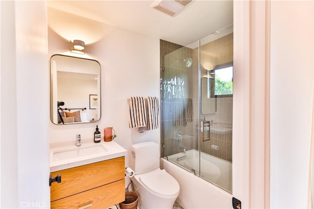 full bathroom with toilet, shower / bath combination with glass door, and vanity